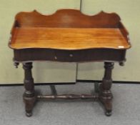 A Victorian mahogany desk, of serpentine form, with a front drawer and carved back,