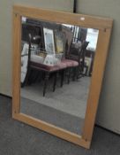 A modern rectangular wall mirror set in an oak frame,