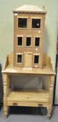 A contemporary dolls house containing a selection of furniture,