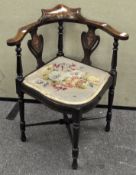 An Edwardian bow fronted mahogany inlaid corner chair, the seat upholstered with floral needlework,