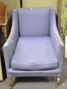 A blue armchair , early 20th century, raised on squared supports,