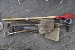 A collection of garden tools including spades,