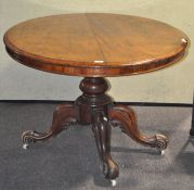 A Victorian mahogany tilt top table with quad form pedestal base on casters,