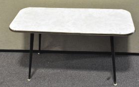 A vintage coffee table of rectangular form, rounded edges, on splayed supports,