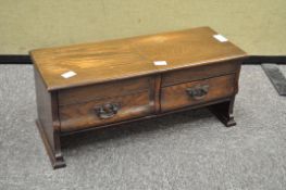 A small table top cabinet, comprising two short over two long drawers,