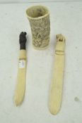 Two carved ivory knives and a pierced worked ivory pot, lacking base,