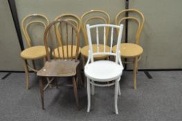 A set of four tan painted wooden chairs with balloon shaped backs and circular seats,