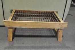 An early 20th century garden potting table, wooden border and supports with metal slats to centre,