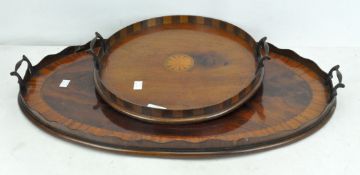 Two Victorian style inlaid mahogany butlers trays, one of oval form, the other circular form,
