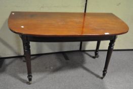 An Edwardian mahogany ''D' end table with turned legs, on casters,