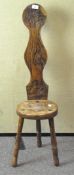 A 20th Century oak stool, carved with images of leaves and roses, on turned legs,