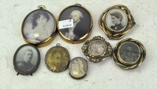 A collection of metal mounted picture brooches,