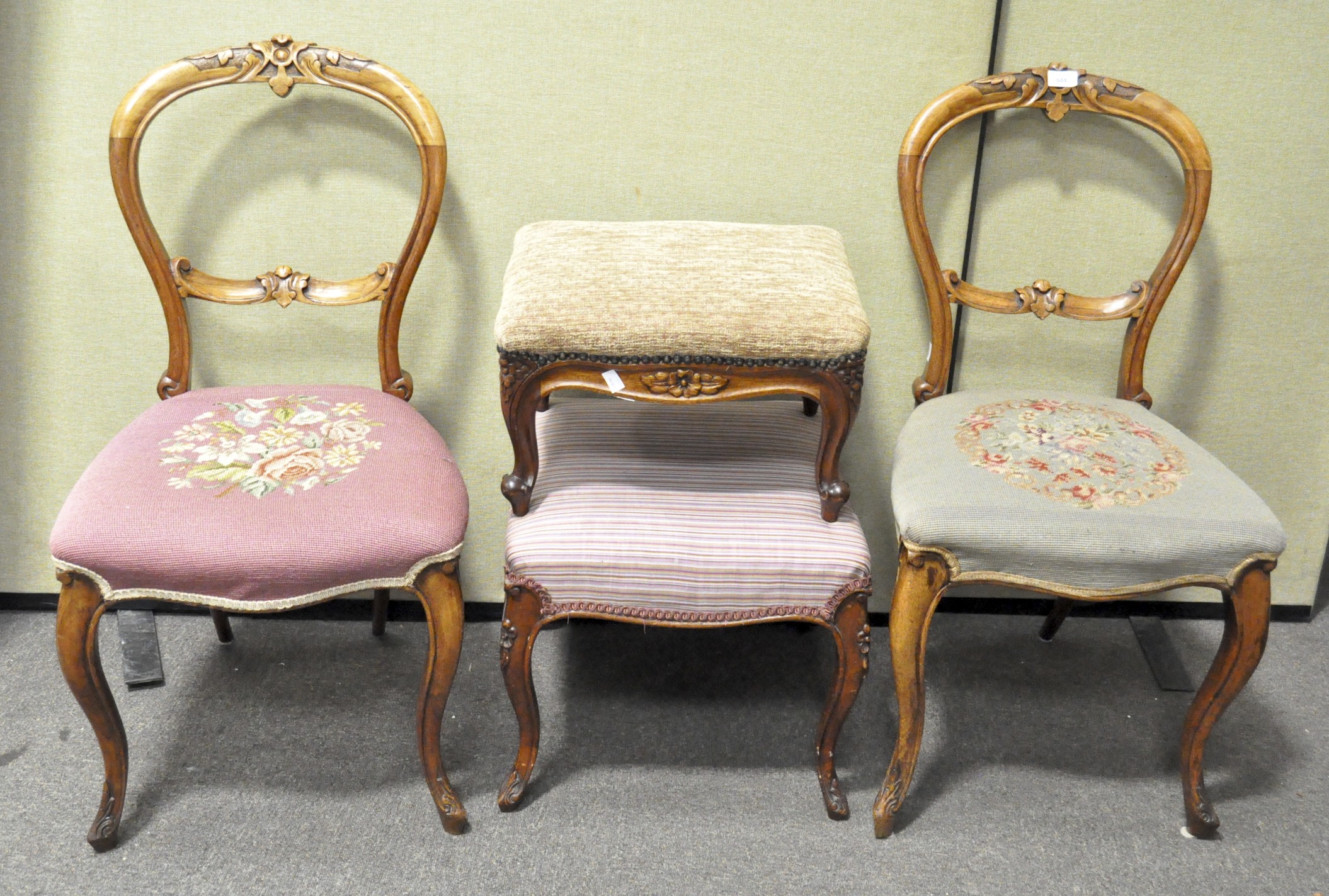A pair of Victorian balloon back chairs with carved floral details and tapestry upholstered seats,