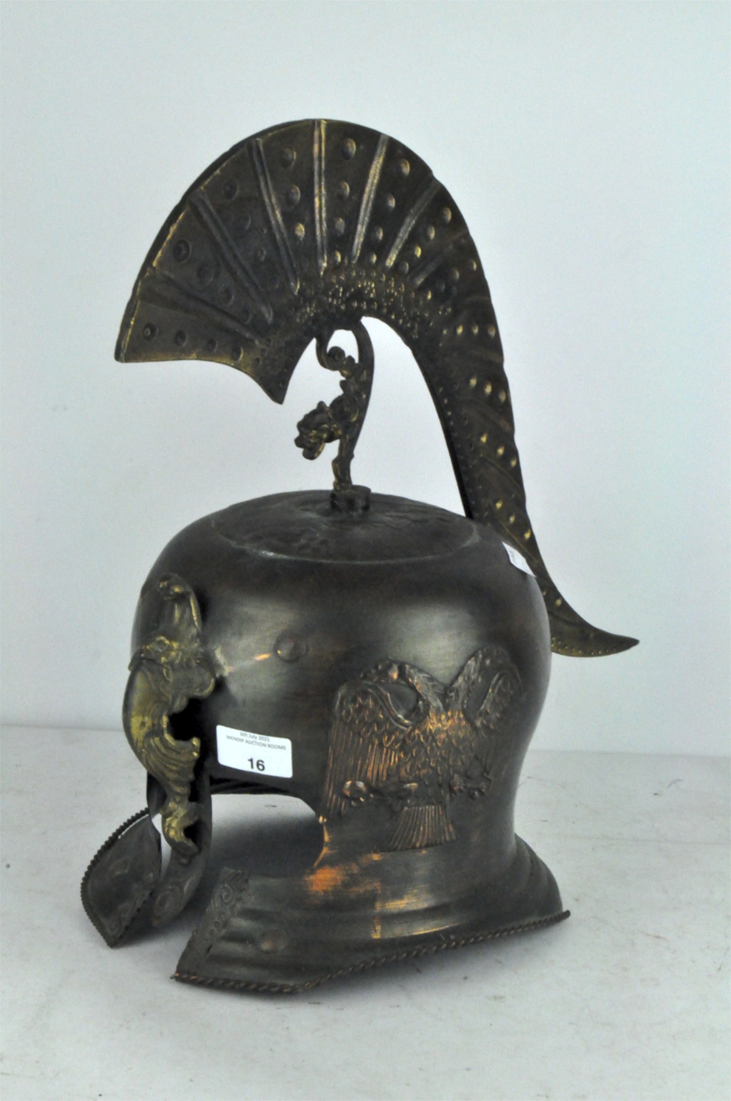 A modern reproduction metal helmet, in the classical style, with flowing metal finial,