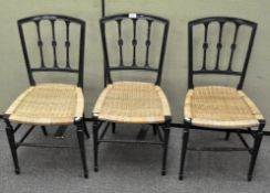 A set of three Regency style wicker seat chairs, each with three spindles with carved rosettes,