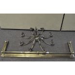 An eight light brass chandelier and a brass fender with ball finials,