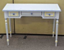 A blue painted desk with three frieze drawers on reeded legs,
