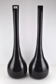 Two large opaque black glass vases of tapering bud form,