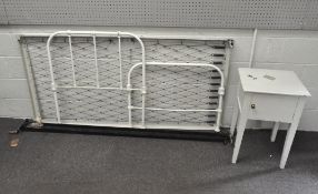 A white painted iron single bedstead on wheels, 98 cm high, and a white painted pot cupboard,