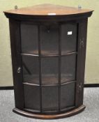 A mahogany glazed corner cabinet, hinged door with glass panels, two shelves to the interior,