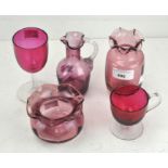 A collection of cranberry glass, to include a spirially moulded jug, two vases,
