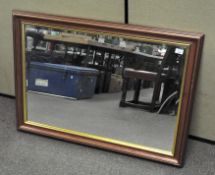 A modern wood and parcel gilt bevelled edge mirror,