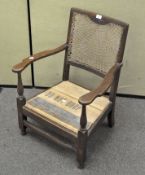 A,low oak bergere backed armchair with a carved half flower motif finial,