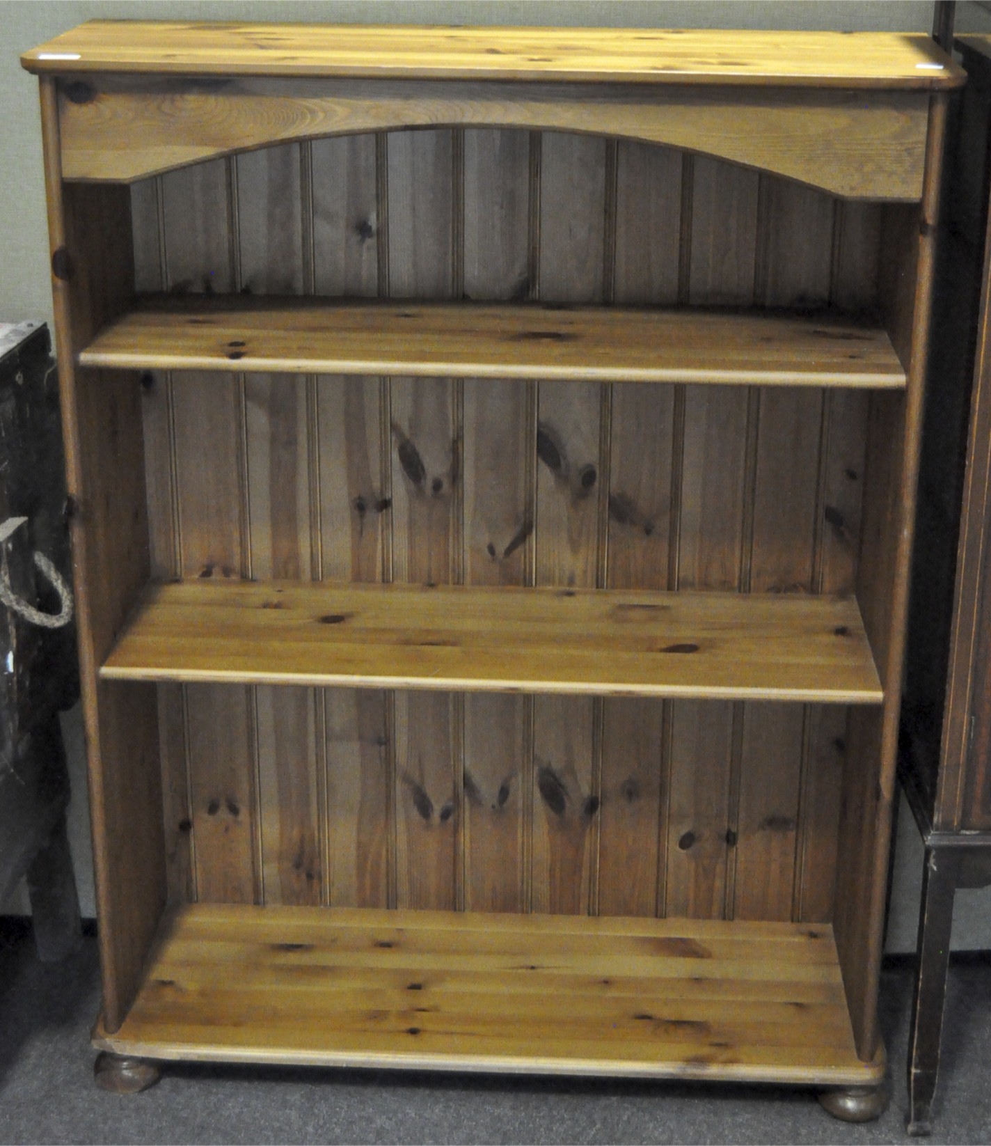 A contemporary pine bookcase, with two shelves, raised on turned supports,