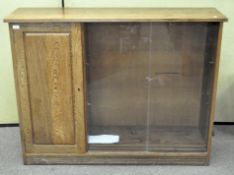 A 20th century oak display or book cabinet with two shelves behind one lockable door (with key),