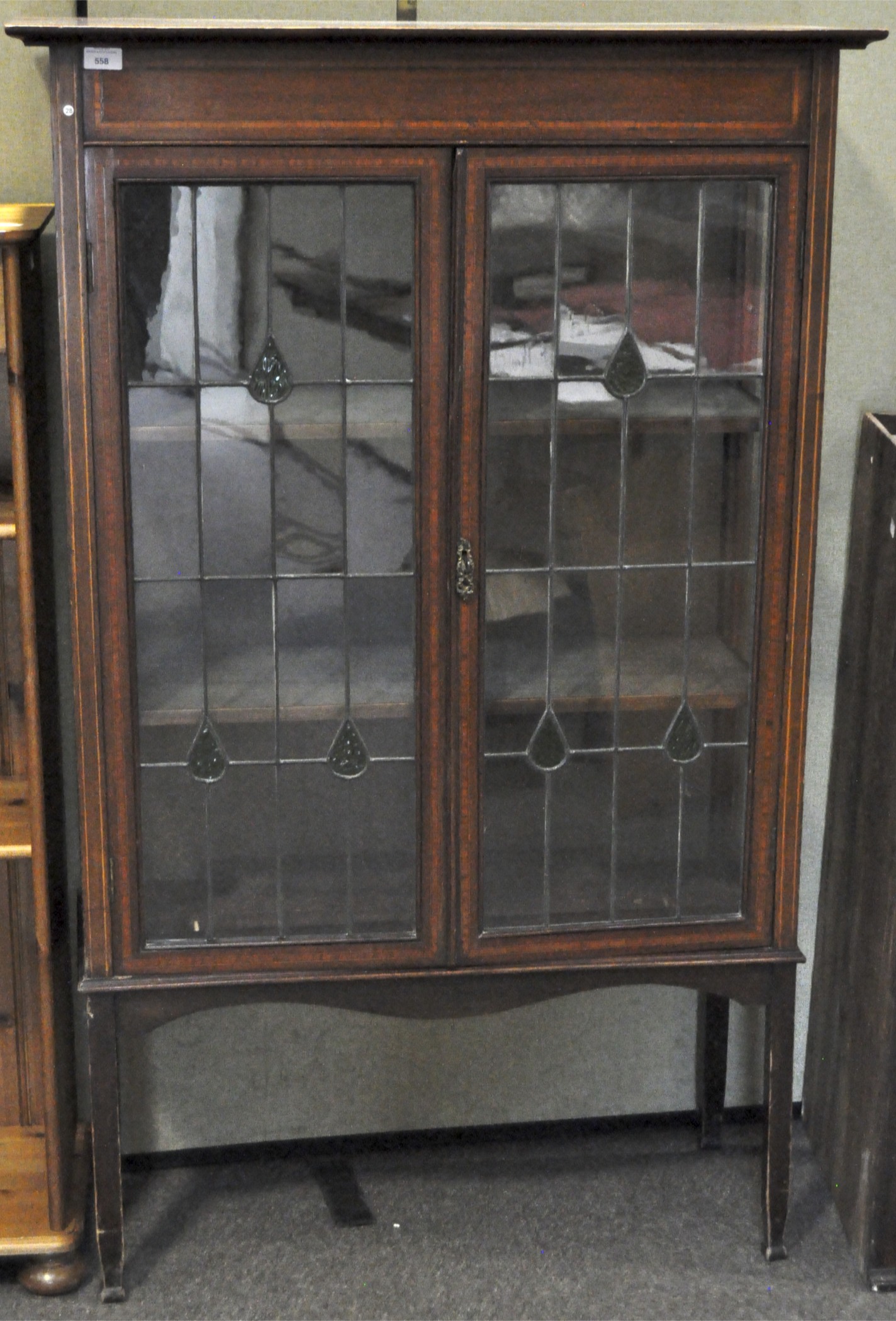 Art Nouveau style mahogany glazed cabinet, with two shelves, on tapering square feet,