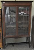 Art Nouveau style mahogany glazed cabinet, with two shelves, on tapering square feet,