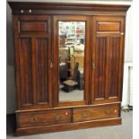 A Victorian mahogany compactum wardrobe with central rectangular mirror flanked by ribbed panels,