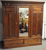 A Victorian mahogany compactum wardrobe with central rectangular mirror flanked by ribbed panels,