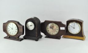 Four contemporary mantel clocks, battery powered, in wooden cases,