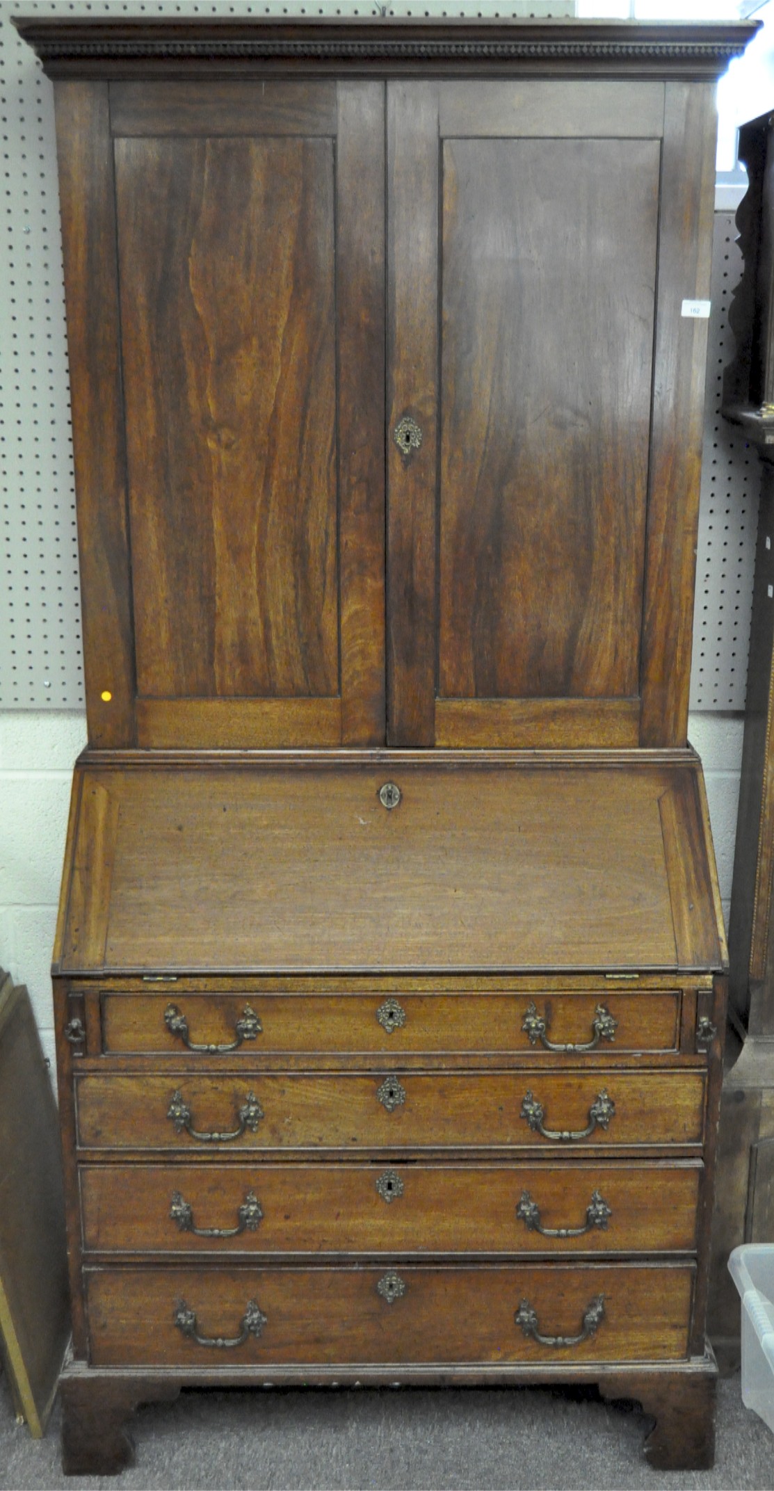 A George III style mahogany bureau bookcase, with two hinged panelled doors revealing two shelves,