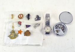 A collection of small brooches including a star, a wasp and a Red Cross Society badge,