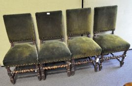 A set of four oak framed dining chairs with barley twist supports, upholstered in green velvet,