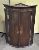 A 18th Century stained oak corner cupboard, with brass lock and fittings,