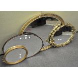 A large oval gilt mirror together with a wood framed oval mirror and two further mirrors,