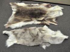 Two reindeer skin fur rugs, of grey hues,
