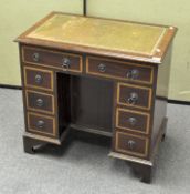 A small inlaid mahogany eight drawer writing desk with embossed green leather insert,