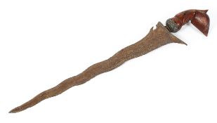 A Malaysian or Indonesian Kris, 19th century, the wave shaped blade with a carved hilt,