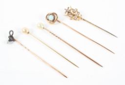 A collection of pins consisting of a knot pin with central opal and four pearl set pins