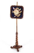 A Victorian walnut pole screen circa 1860, on barley twist stem,