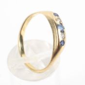 A yellow metal half hoop ring set with alternating blue sapphire and diamonds.