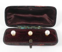 A cased set of three 9ct gold gents dress shirt studs, each adorned with a single pearl,