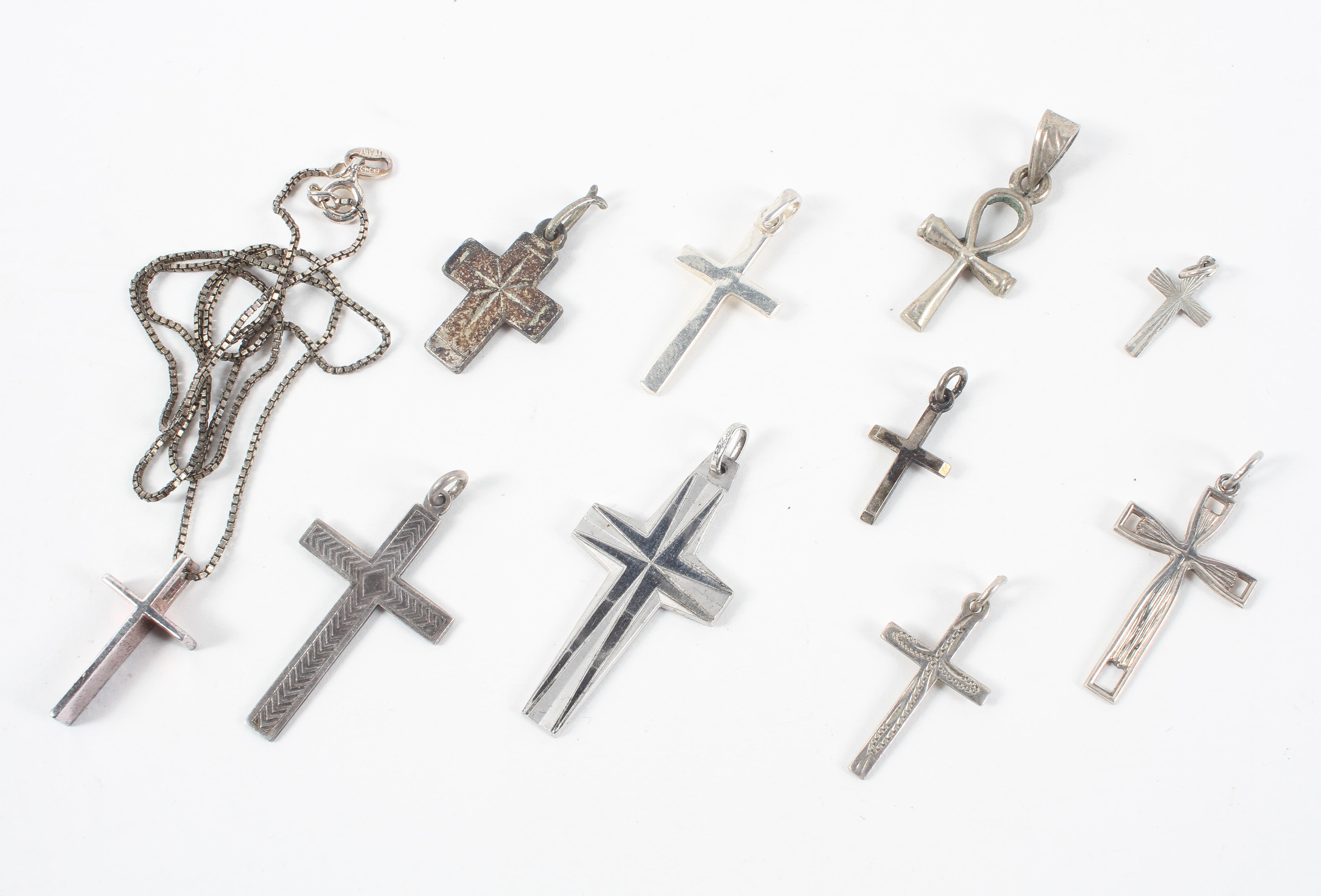A collection of ten cross pendants, one with chain.