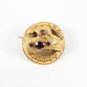 A yellow metal brooch of abstract design set with garnets (untested due to size and setting)