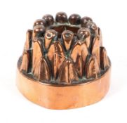 A Victorian copper jelly mould, 19th century, of traditional tiered arched ring form,