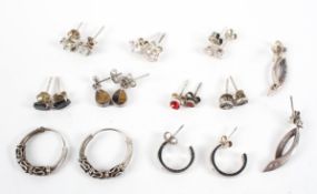 A collection of ten pairs of silver earrings of varying designs,